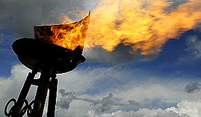 Pebetero con el fuego olímpico sobre un cielo con nubes